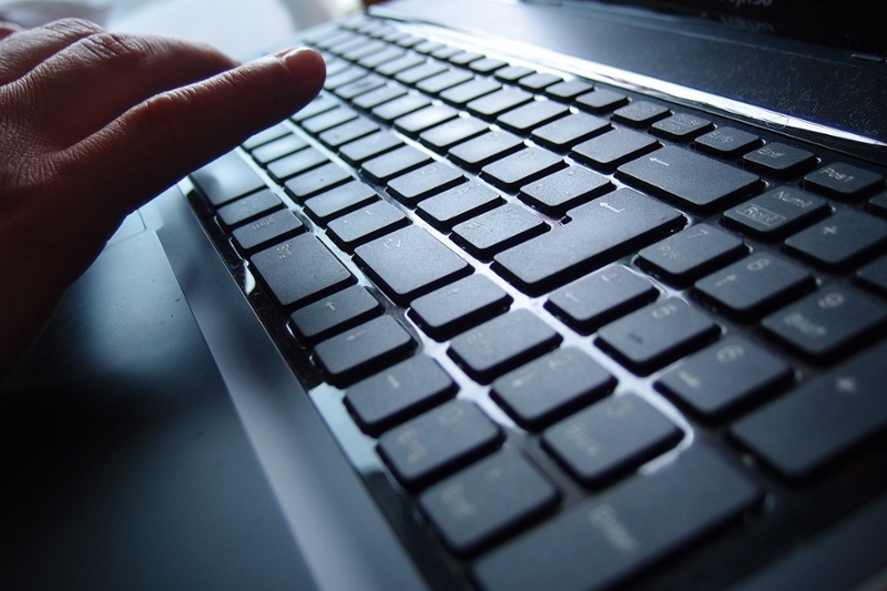 Hand boven een toetsenbord van een laptop