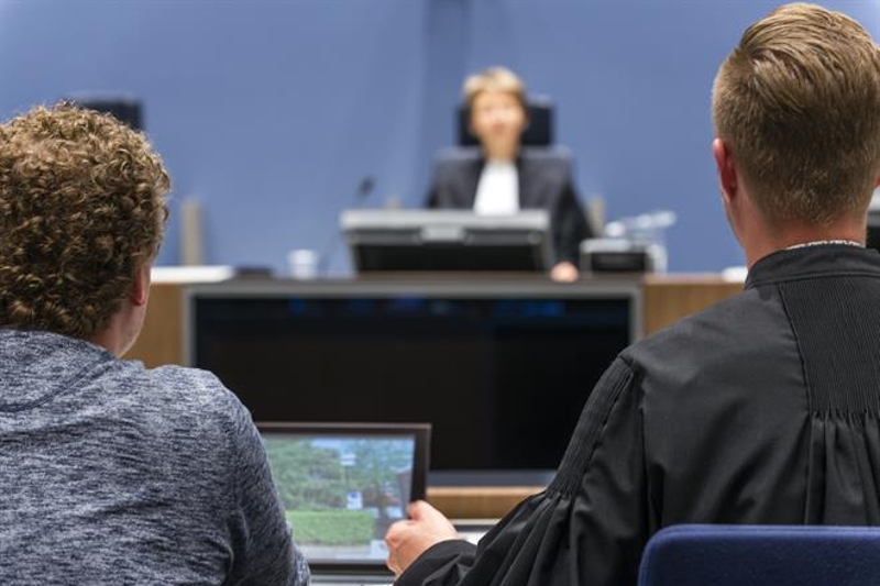 Verdachte en advocaat in rechtbank van achter gefotografeerd